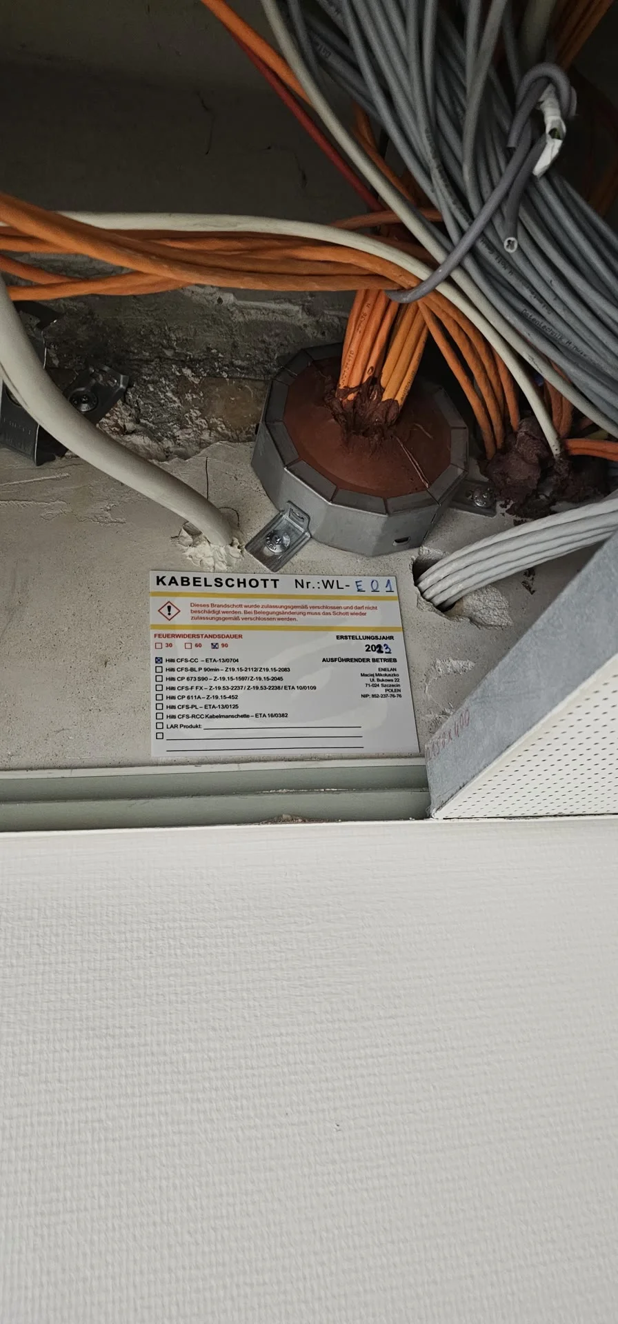 Brandschutz-Kabelschott mit Zertifikatsplakette — fachgerechte Abschottung nach DIN VDE 0100.