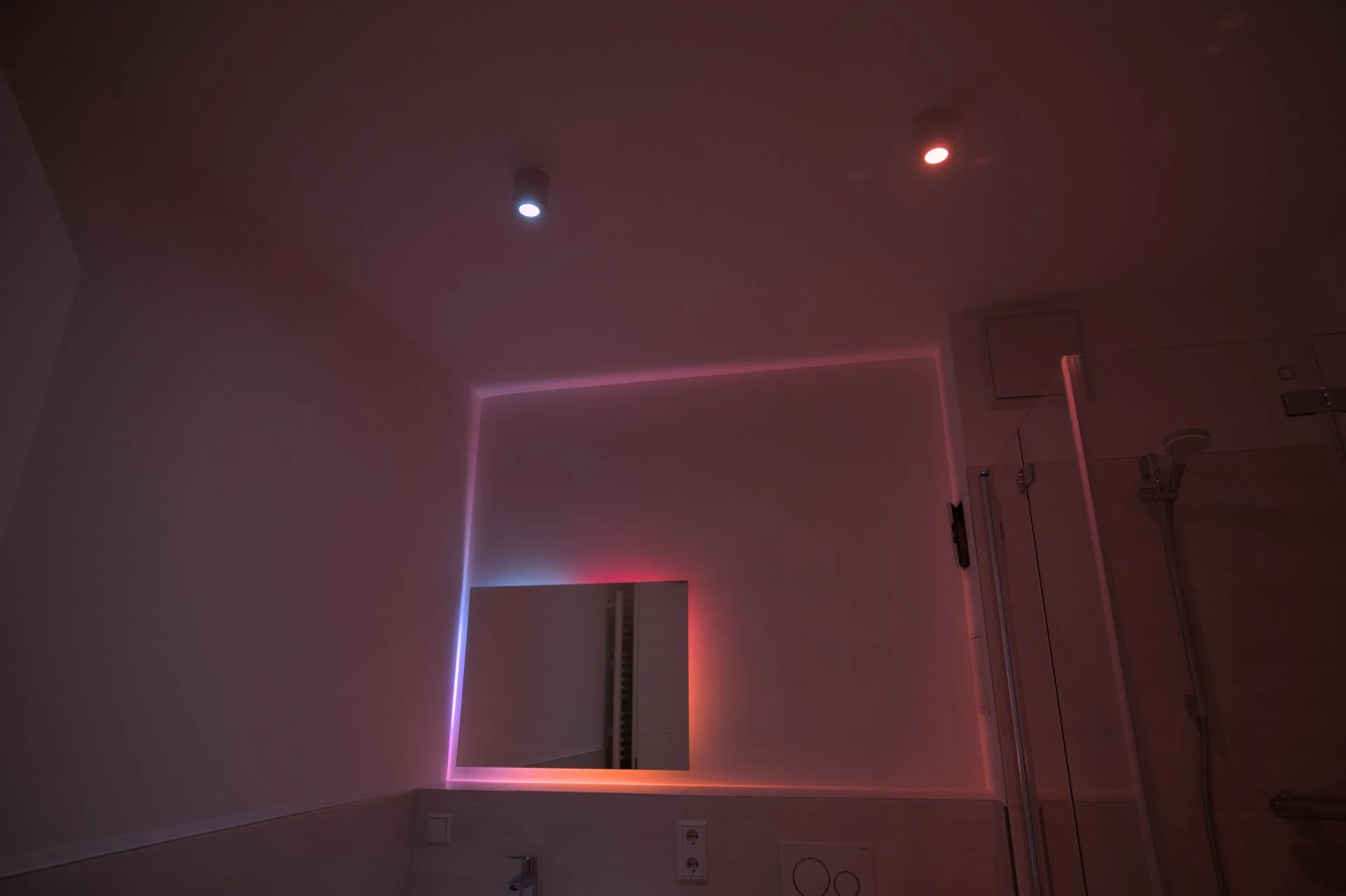 Indirekte LED-Beleuchtung im Badezimmer mit Philips Hue — programmierbare Lichtszenen in Magenta und Rot, geplant und installiert von ENELAN GmbH.