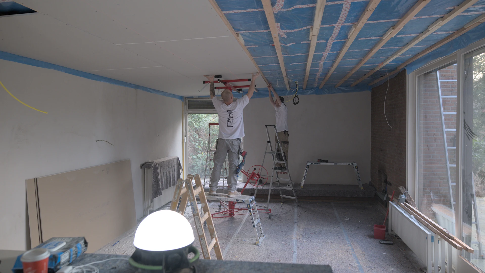 Wand- und Deckenfinish nach Elektroinstallation — zwei ENELAN-Handwerker bei der Trockenbau- und Verputzarbeit in einem Hamburger Sanierungsprojekt.
