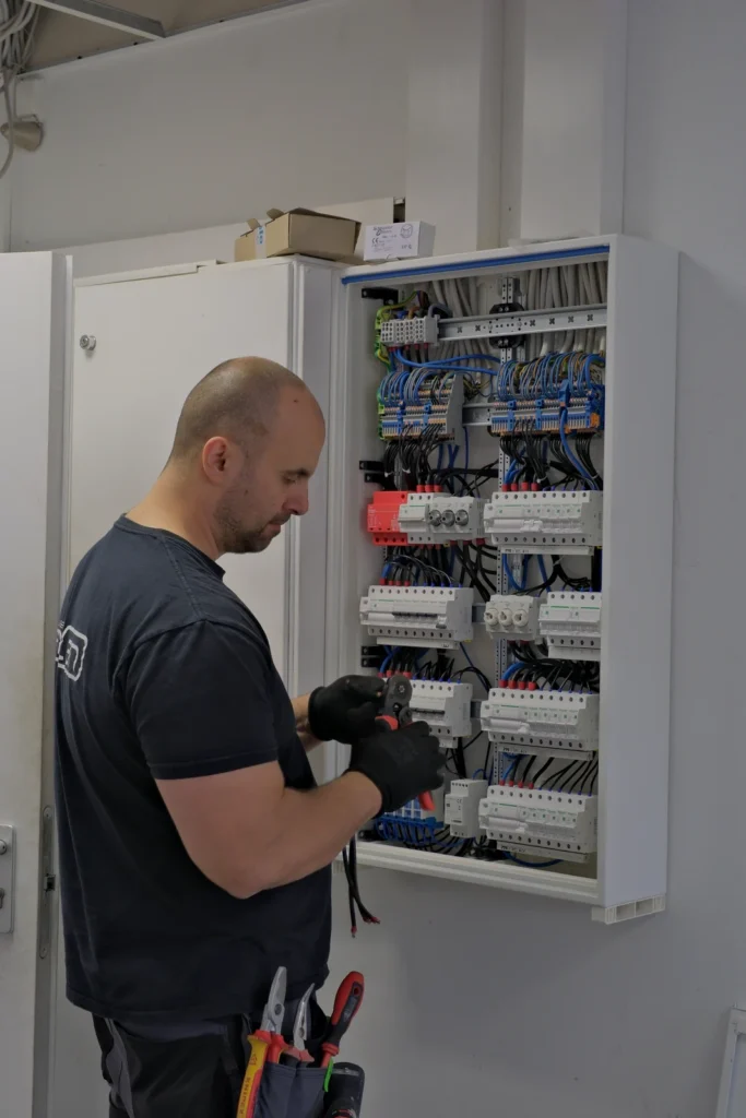 ENELAN-Techniker verdrahtet eine Schaltanlage mit Reihenklemmen