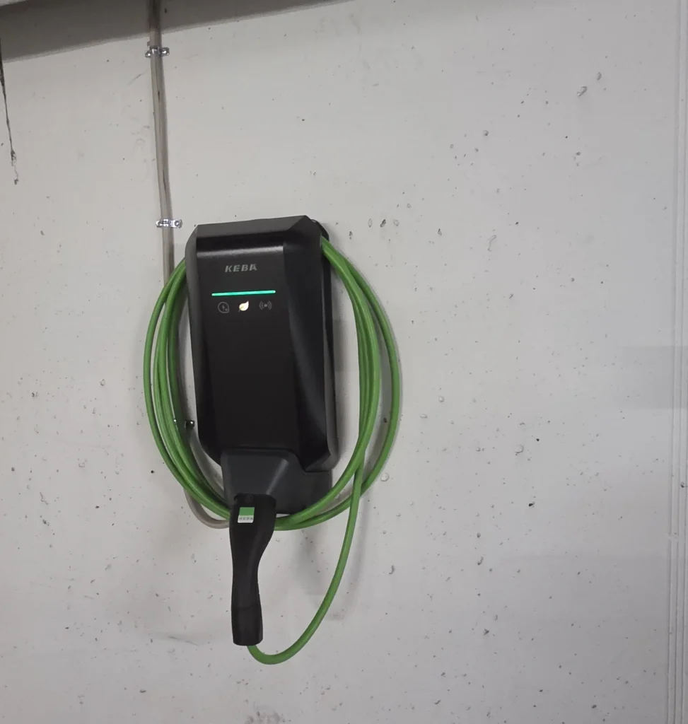 KEBA-Wallbox mit Ladekabel an der Wand einer Tiefgarage in Hamburg