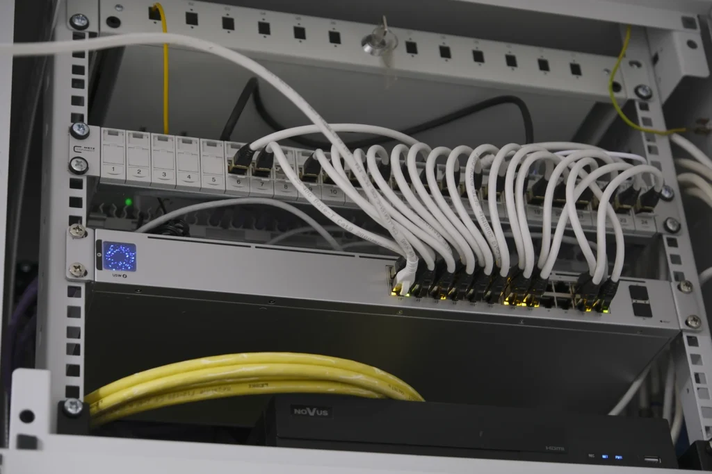 Netzwerkschrank mit Patchfeld, Switch und sortierten Patchkabeln
