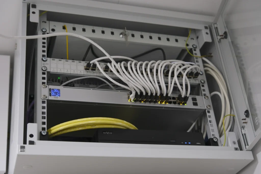 Wandmontierter Netzwerkschrank mit Glasfaserzuleitung und Patchfeld