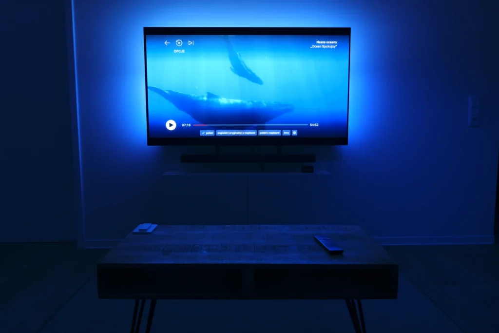 Wohnzimmer mit Fernseher, Soundbar und blauer Akzentbeleuchtung