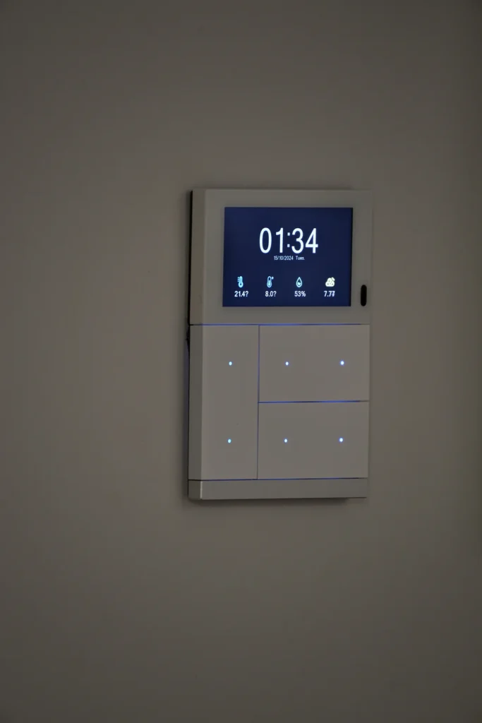 KNX-Raumcontroller mit Display und Tastsensor an der Wand