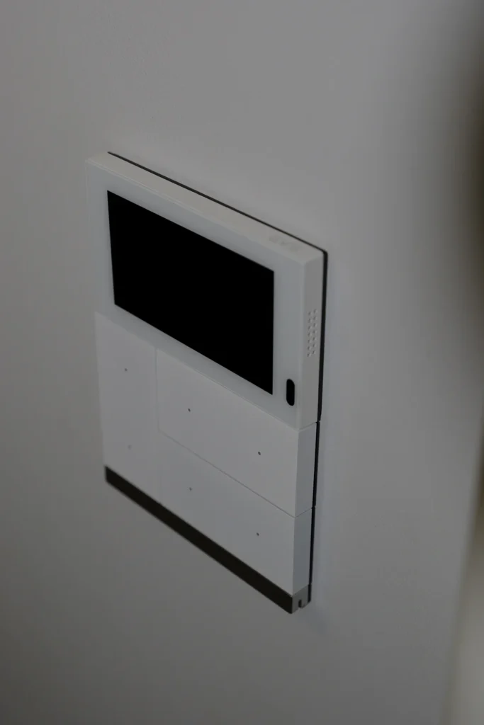 Innenstation einer Türsprechanlage mit Display, seitliche Ansicht an der Wand