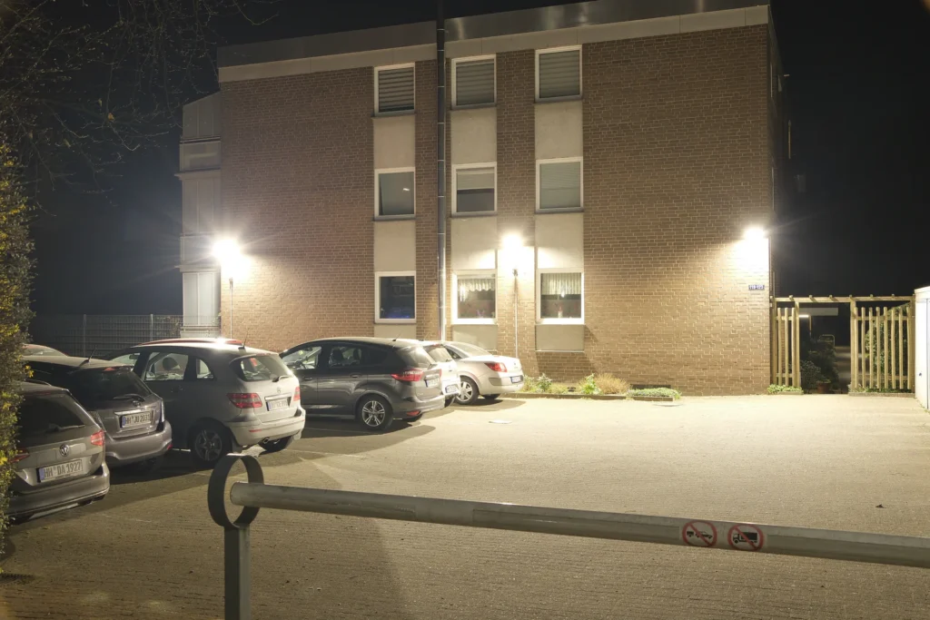 Nachts ausgeleuchteter Parkplatz vor einem Wohngebäude in Hamburg