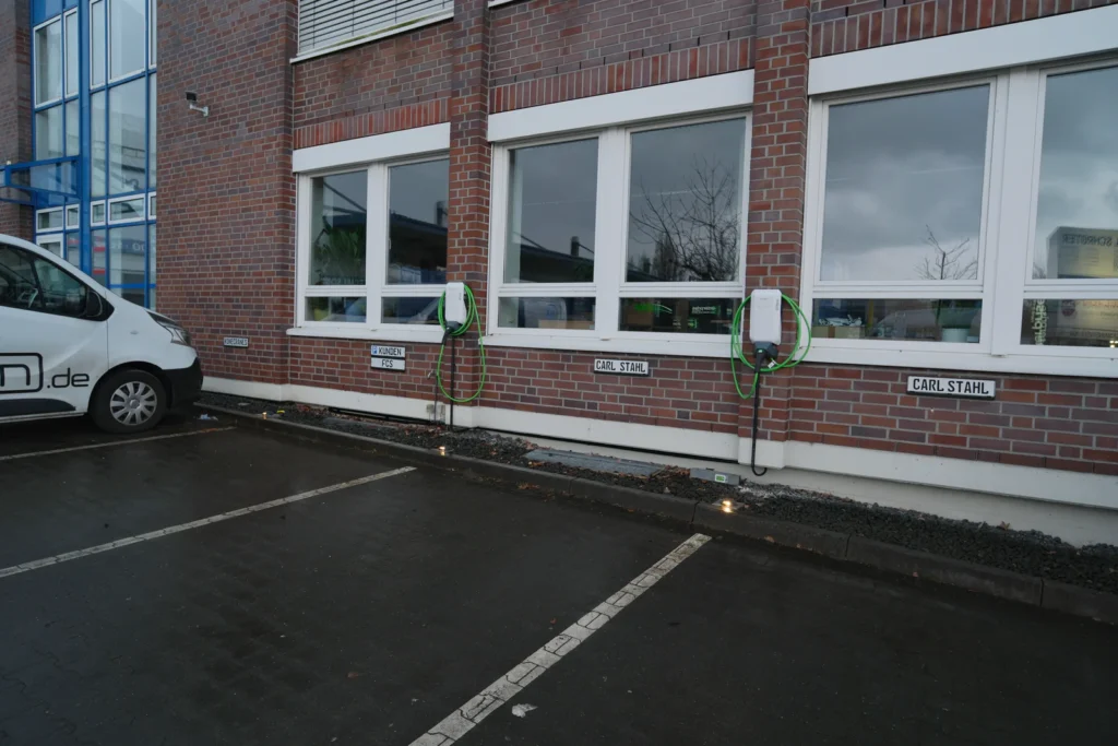 Kundenparkplatz mit zwei Wallbox-Ladepunkten an der Gebäudewand