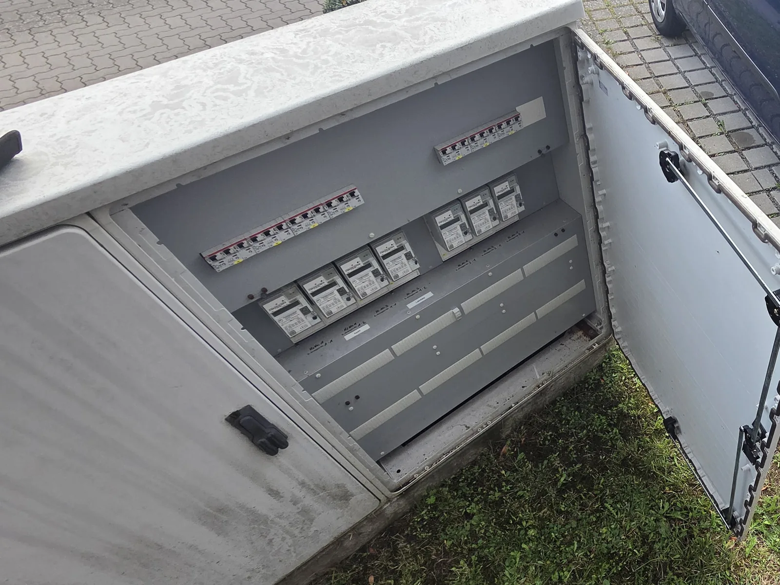 Geöffnete Außen-Zähleranlage auf Betonsockel mit sieben Zählern und Leitungsschutzschaltern