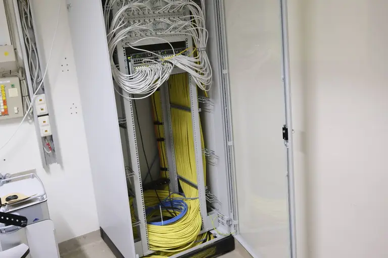 Geöffneter Netzwerkschrank mit Patchfeldern und strukturierter Datenverkabelung in einem Gewerbeobjekt